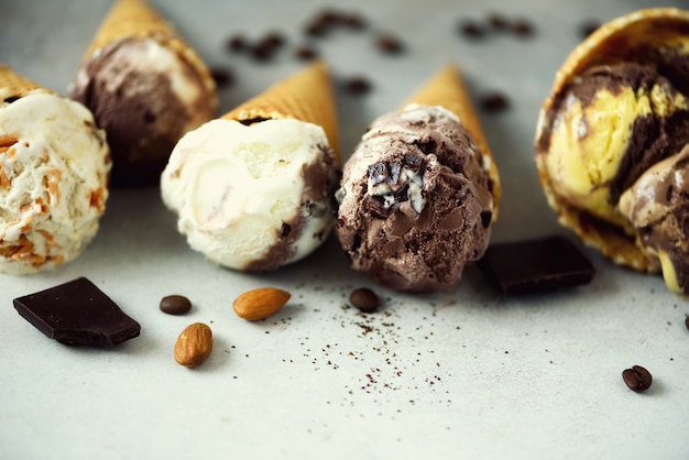 Gelado do chocolate e do café no cone do waffle com os feijões de café na pedra cinzenta. Conceito de comida de verão, copie o espaço. Gelado sem glúten saudável. Vista do topo