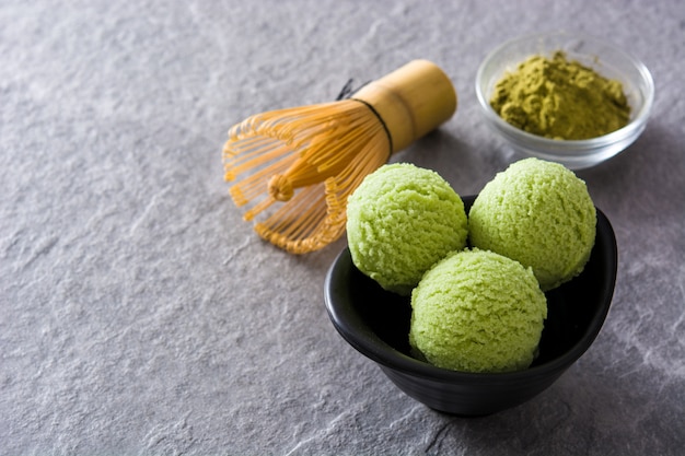 Gelado matcha de chá verde colheres na pedra cinza com espaço de cópia