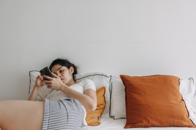 Gelangweilte Frau nutzt Smartphone-Social-Media, um die Zeit in der Wohnung totzuschlagen