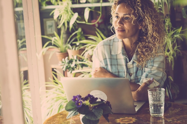 Gelassene Menschen nach der Arbeit online mit Laptop-Computer Fröhliches, selbstbewusstes Porträt einer erwachsenen Frau, die eine Pause nach einem digitalen Job genießt Konzept von Menschen in intelligenter Arbeit, die am Tisch sitzen