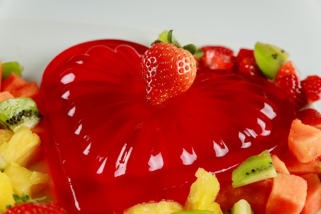 Gelatina de corazón de fresa con frutas en plato blanco