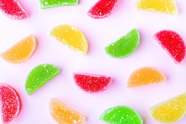 Gelatina de frutas coloridas com cristais de açúcar, em um fundo rosa