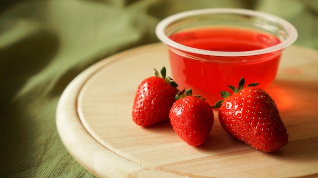 Gelatina de fresa roja con frutos rojos en un recipiente de plástico