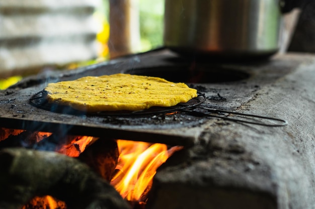 Gelbe Arepa wird auf einem handgefertigten Ziegelofen mit Holz als Brennstoff traditionell kolumbianisch gegrillt