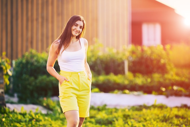 Gelbe Bermuda-Shorts werden von jungen europäischen Frauen an Sommerabenden auf dem Land getragen.