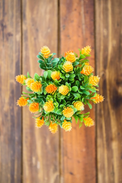 Foto gelbe blumen in einem vase auf hölzerner tabelle