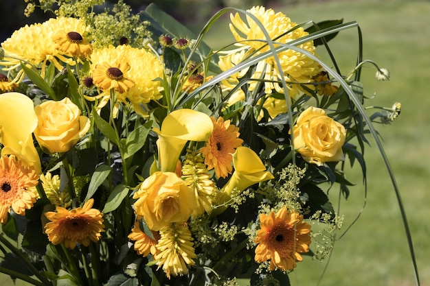 Gelbe Blumen in einer Vase auf einem Gartentisch