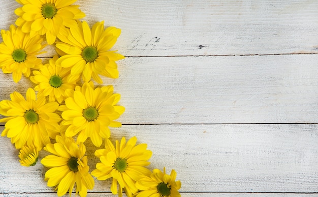 Gelbe Blumen über gemaltem hölzernem Hintergrund für Text