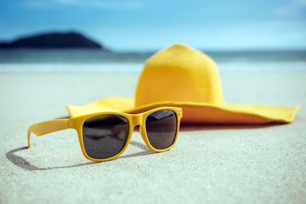 Foto gelbe brille und hut am strand