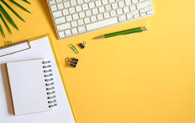 Gelbe Bürotischplatte mit Tastatur und Schreibwaren