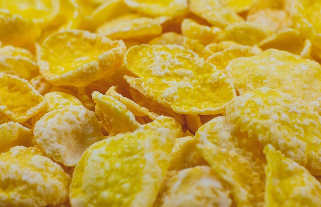 Gelbe Cornflakes Nahaufnahme Foto, Lebensmittel Textur Hintergrund, Ansicht von oben. Makroaufnahme. Perfektes Frühstück.