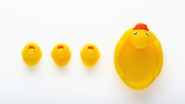 Gelbe Entenküken des Draufsichtspielzeugs mit Mutterente auf weißem Hintergrund, Familienkonzept