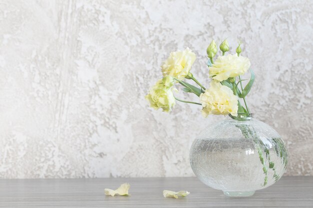 Gelbe Eustoma in Glasvase auf dem Tisch