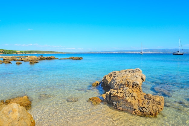 Gelbe Felsen und blaues Wasser in Lazzaretto setzen Italien auf den Strand