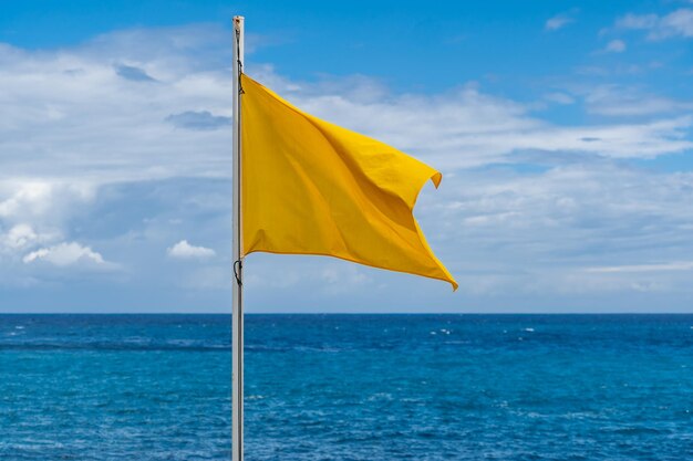 Gelbe Flagge auf dem Strand im Sommer Sommer Rettungsschwimmer Zeichen, um vorsichtig zu baden