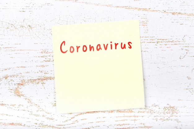 Foto gelbe haftnotiz mit erinnerung an die gefahr eines coronavirus