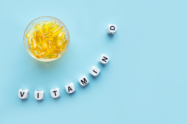 Foto gelbe kapseln in der runden glasschüssel und das wort vitamin d