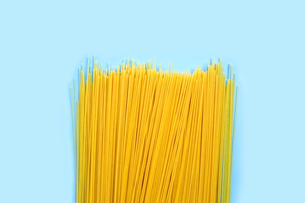 Gelbe lange Spaghetti auf blauer Oberfläche