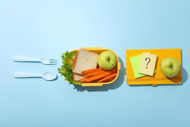 Foto gelbe lunchbox mit brot, apfel und karotte