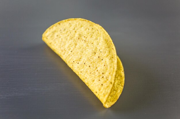 Gelbe Mais-Taco-Schalen auf grauem Hintergrund.