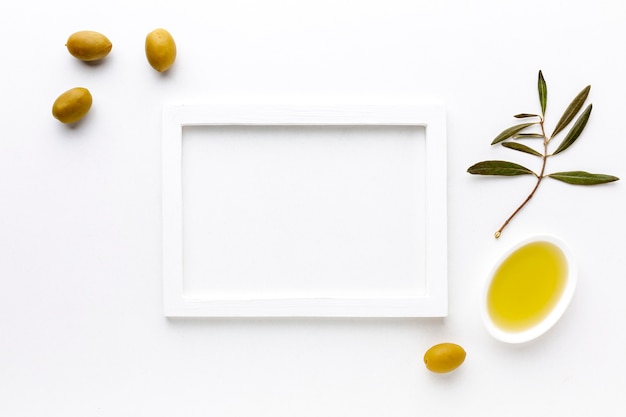 Gelbe Oliven und Öluntertasse mit Rahmenmodell
