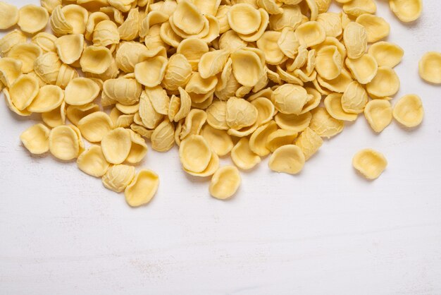 Gelbe Orecchiette-Nudeln auf Holztisch