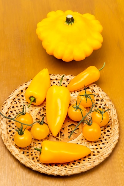 Gelbe Paprika und Tomaten auf Korbteller Gelber Patisson auf dem Tisch