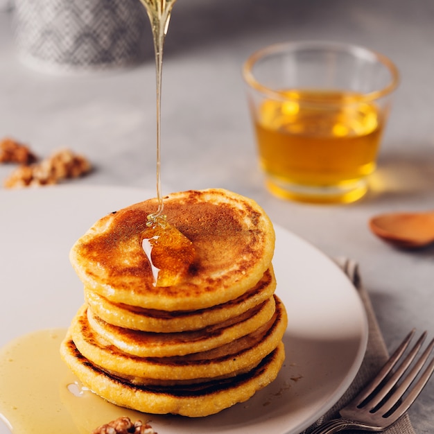 Gelbe Pfannkuchen mit Maismehl und Kurkuma, gekleidetem Honig und