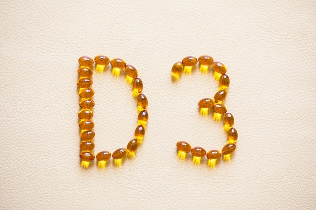 Gelbe Pillen des hellen Öls, die Form bilden D3 Vitamin D3 Kapseln Medizinvitamine und Nahrungsergänzungsmittel