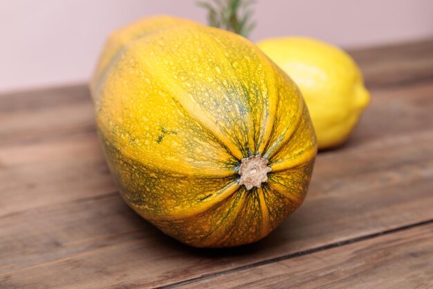 Gelbe reife Zucchini mit Zitrone auf Holzplatten Herbstkonzept