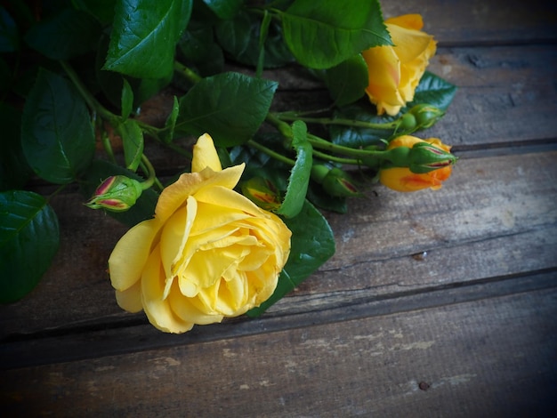 Gelbe Rosen auf einem hölzernen Hintergrund Schöner Blumenstrauß aus 3 Rosen auf einem dunklen Holztisch Grußkarte mit 8. März Muttertag oder Valentinstag