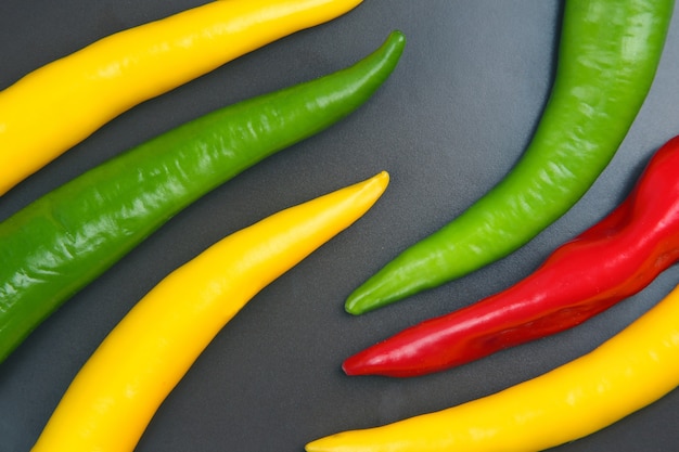 Gelbe, rote und grüne scharfe Chili auf einem Teller. Pfeffer. Pflanzliche Vitaminnahrung.