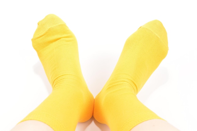 Gelbe Socken am Frauenfuß lokalisiert auf weißem Hintergrund