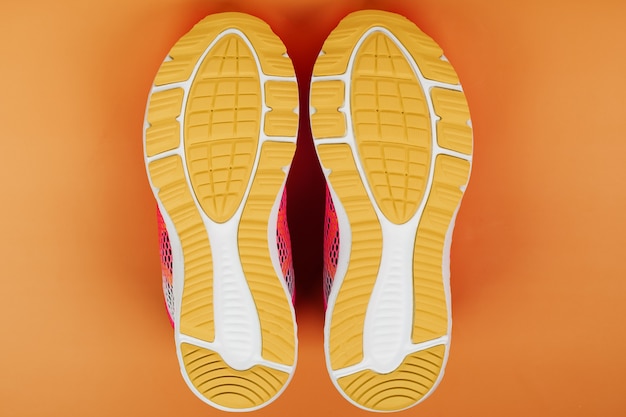 Gelbe Sohle eines Sneakers isoliert auf Orange