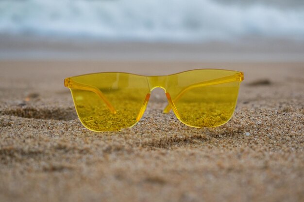 Gelbe Sonnenbrille getrennt über dem Strandhintergrund