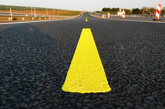 Gelbe Straßenmarkierungen auf Asphaltstraße schließen