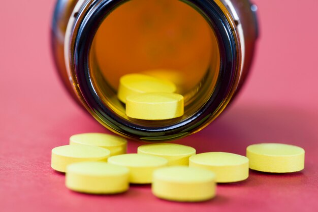 Gelbe Tabletten, die in der Nähe der Glasverpackung lagen, wurden zum Schutz der Medikamente aus einer dunklen Glasdose entnommen