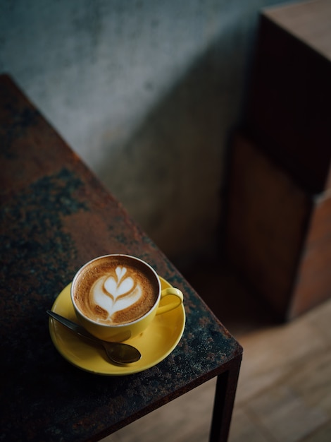 gelbe Tasse Kaffee Latte Kunst im Café Cafe