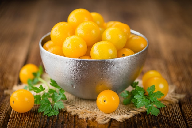 Gelbe Tomaten auf selektivem Fokus des hölzernen Hintergrundes