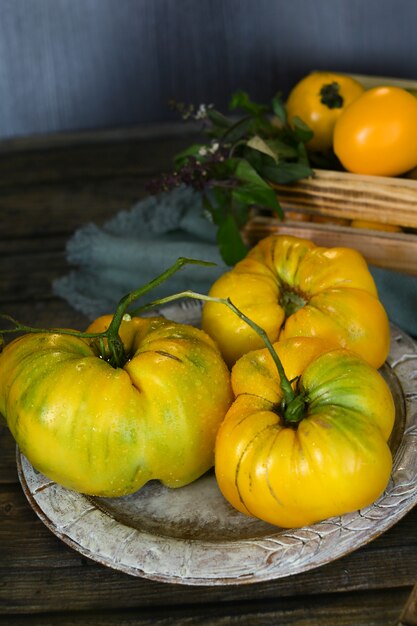 Gelbe Tomaten in der Holzschale auf einem Tisch.