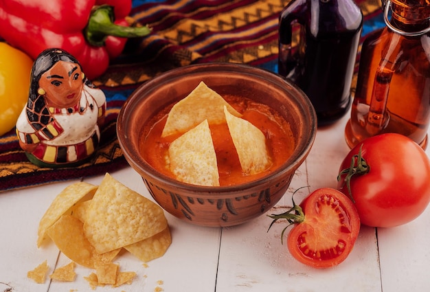 Gelbe Tortillachips und Salsa auf weißem Tisch