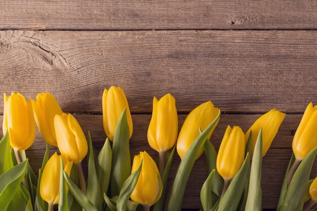 Gelbe Tulpen über hölzernen Tischhintergrund