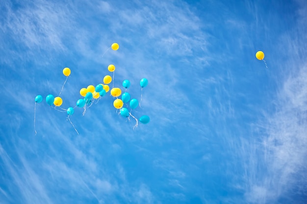 Gelbe und blaue Ballons fliegen in den Himmel