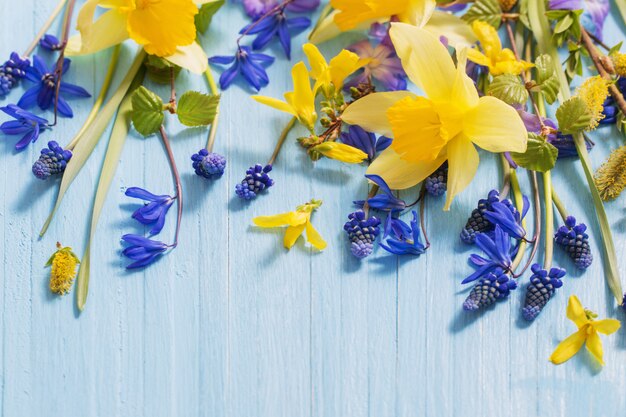 Foto gelbe und blaue frühlingsblumen auf hölzernem hintergrund