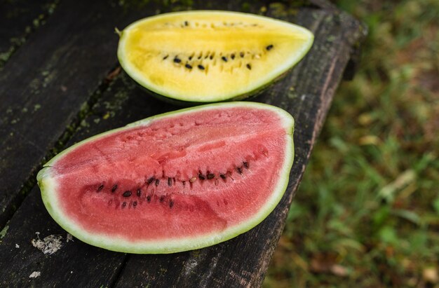 Gelbe und rote Wassermelone auf einer alten Holzoberfläche