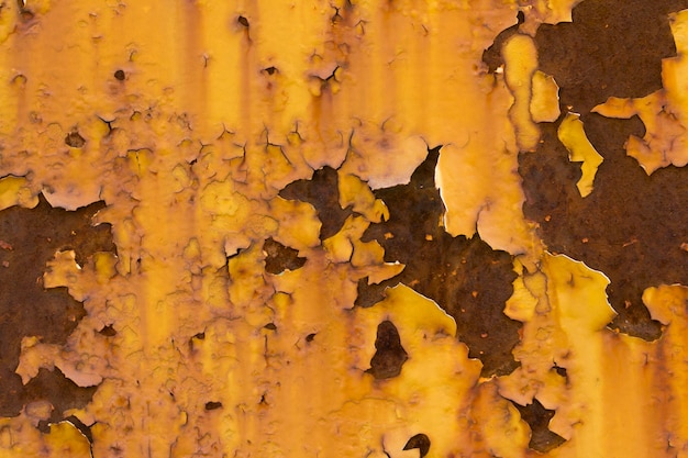 Gelbe Wand mit Rissen und abblätternder Farbe