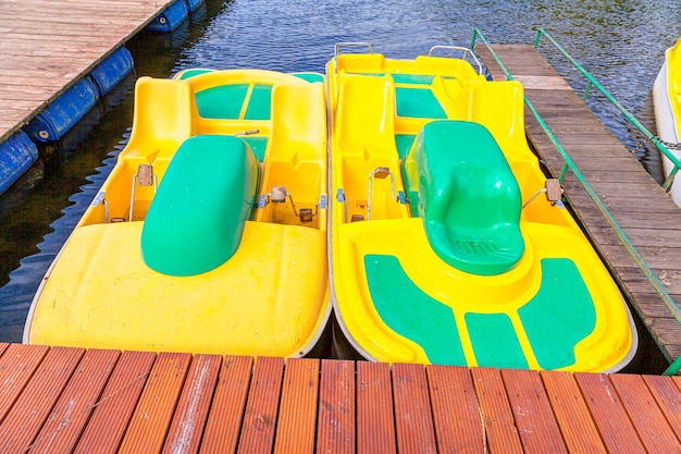 Gelbe Wasserfahrräder, die am sonnigen Sommertag am Hafenhafenpfeiler des Seehafens gesperrt sind