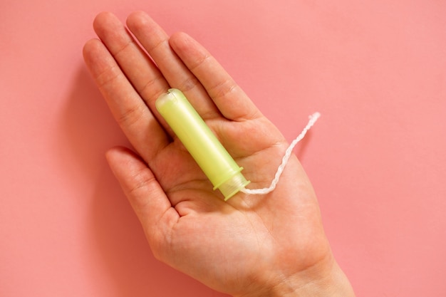 Gelbe weibliche Tampons auf einem rosa Hintergrund