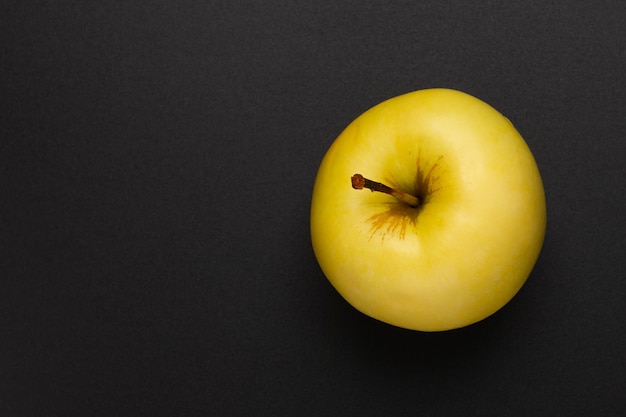 Gelber Apfel auf schwarzem Hintergrund