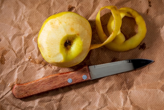 Gelber Apfel (reinetas) halb mit Messer geschält.